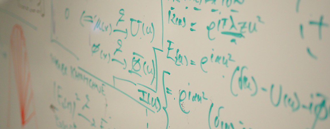 a whiteboard with mathematical writings