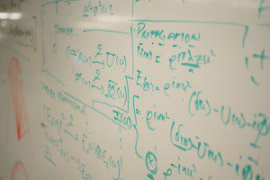 a whiteboard with mathematical writings