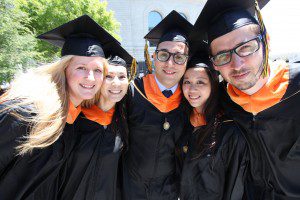 five students posing in graduation caps