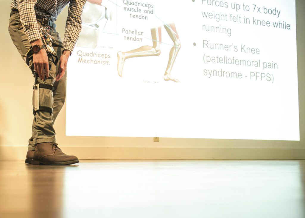student on stage showcasing a leg support device