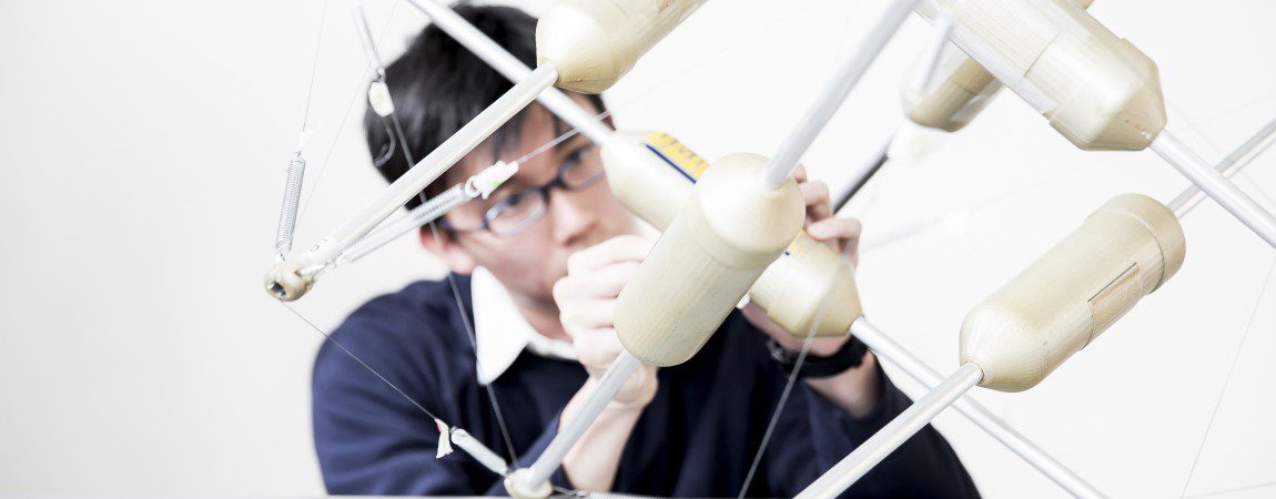 a student adjusting an engineering model