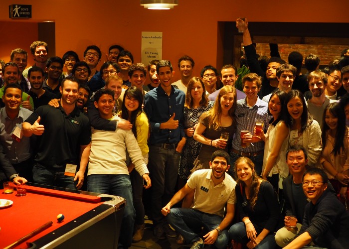 a large group smiling behind a pool table