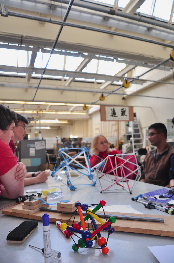 students sitting around a table full of engineering models