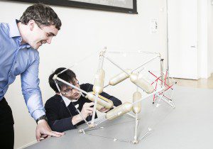 two students working on an engineering model