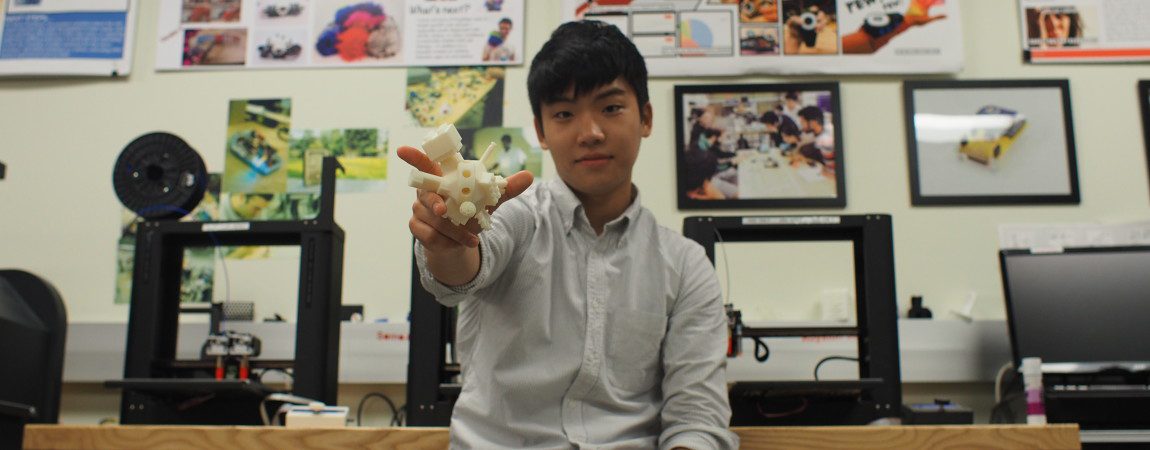 student holding a digital camera prototype