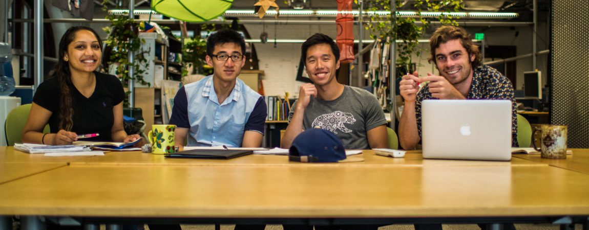 students smiling at a table