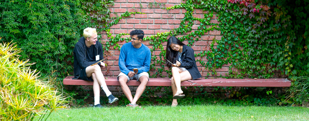 students talking on a courtyard bench