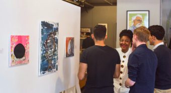 Nelly Alandou (center) discussing her artwork with guests