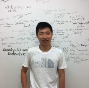 Louis Huang standing in front of a whiteboard