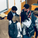 Bird's eye view of Achin Bhowmik speaking to a small group of students in a classroom.