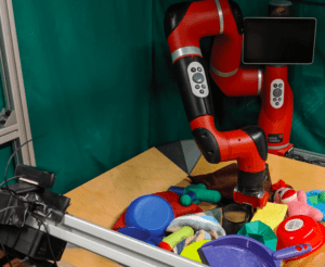A red robot arm in a box of colorful toys.