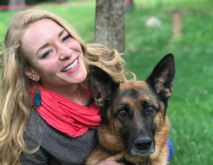 Gina Myers with her dog in an outdoor setting