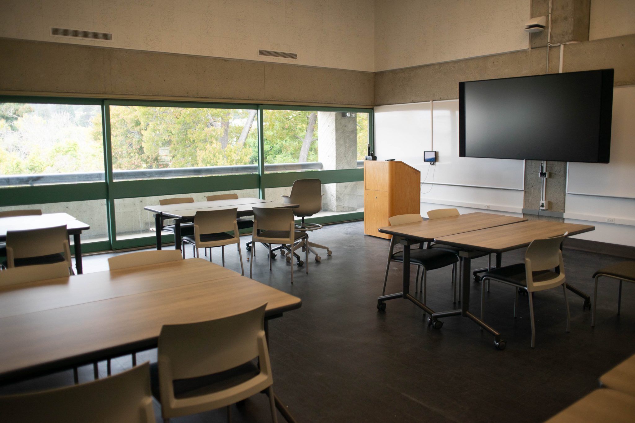 One of the classrooms in Mudd Hall, with groups of tables in front of a podium.