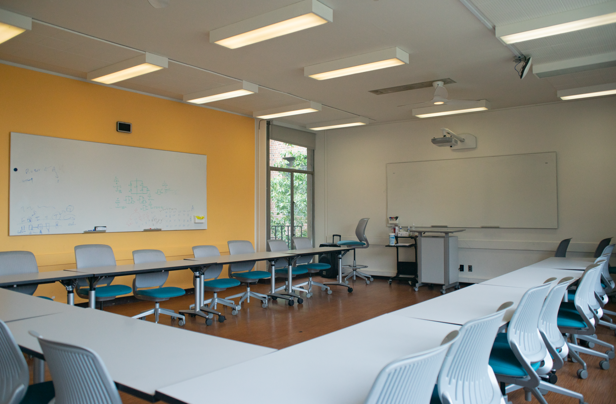 One of the Shires Hall classrooms featuring a semicircle of tables around a podium.