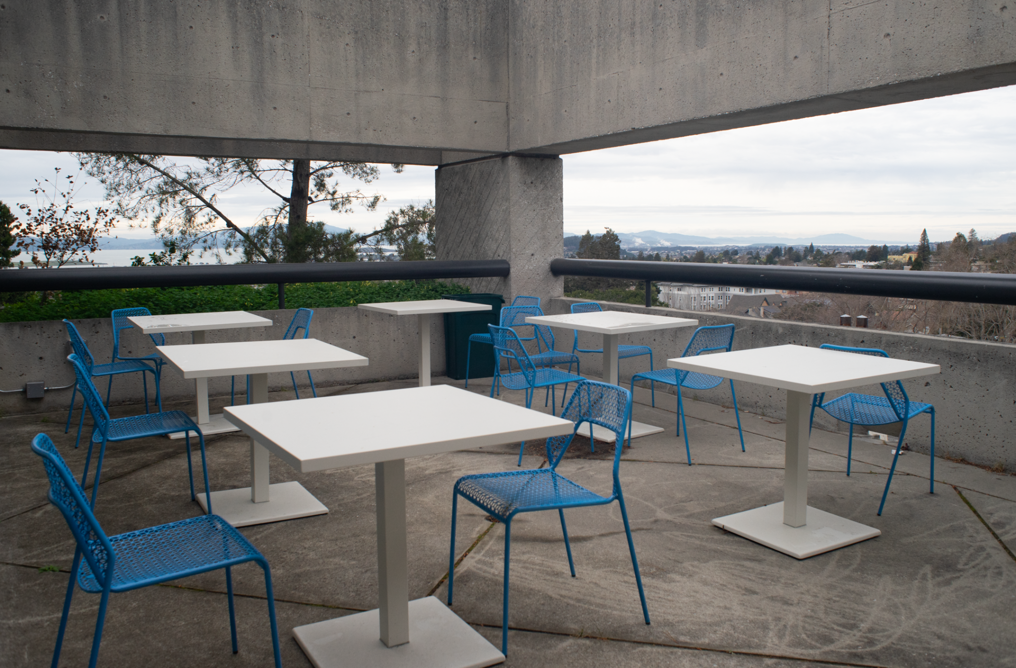 Tables and chairs arranged around the outdoor terrace of Mudd Hall