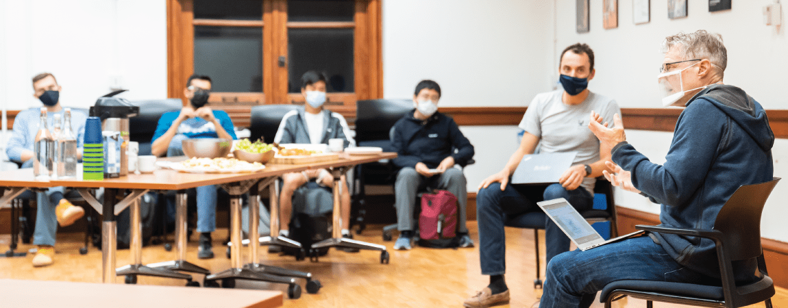 6 people gathered in a classroom wearing masks