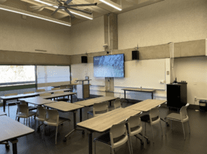 A classroom with a white board and large TV screen in the front of the room