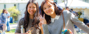 Two students smiling with the peace sign